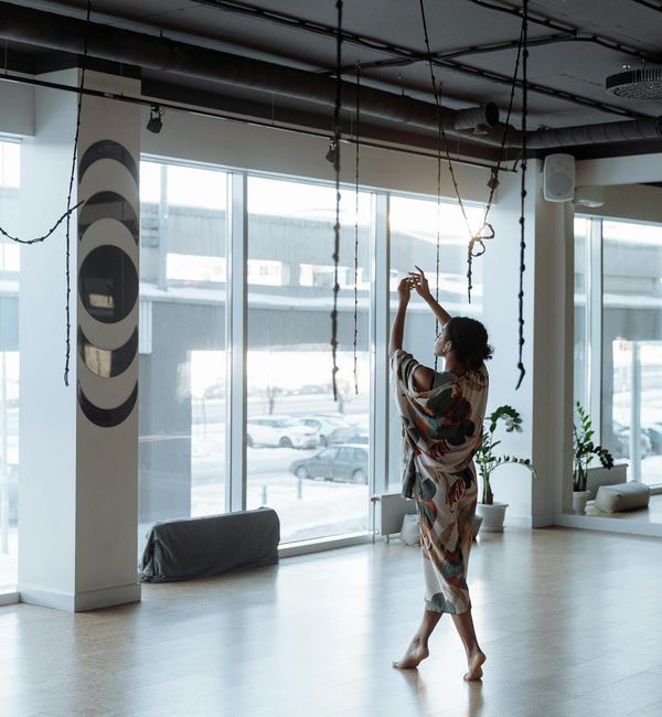 Woman in a graceful morning yoga pose by a window with soft light.